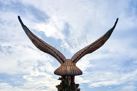 展翅摄影照片_一只展翅的红鹰雕塑。