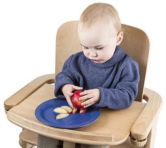 小孩餐具摄影照片_小孩坐在高脚椅上吃桃子