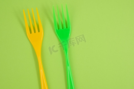 塑料叉子摄影照片_在绿色背景的塑料叉子