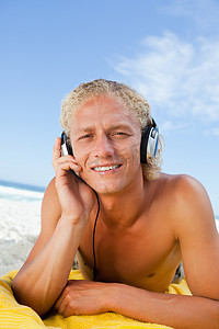 年轻的金发男子用耳机专心听音乐