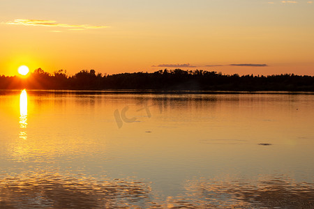 平静的湖面上倒映着五彩缤纷的夕阳。