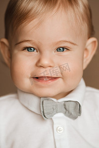 小表情摄影照片_一个快乐的小男孩的肖像，他穿着一件带领结的白衬衫