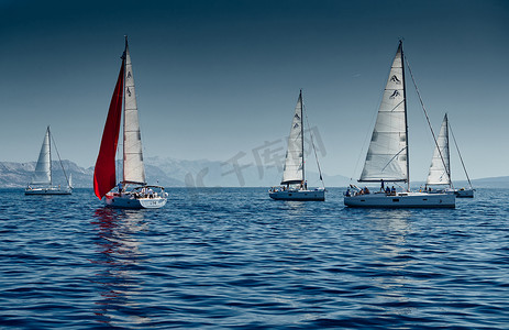 日是背景摄影照片_克罗地亚，亚得里亚海，2019 年 9 月 15 日：背景是帆船比赛、帆船赛、水上帆的倒影、激烈的竞争、鲜艳的色彩、带风车的岛屿
