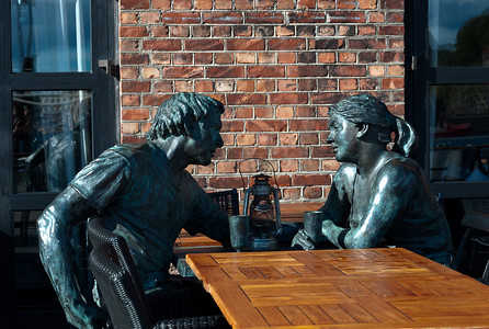 坐在酒吧桌旁的男女雕塑。