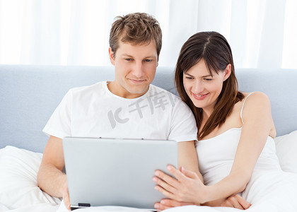 年轻夫妇在家里用电脑看视频