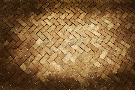 地板铺摄影照片_古老的图案深棕色和浅棕色色调的砖地板铺路人