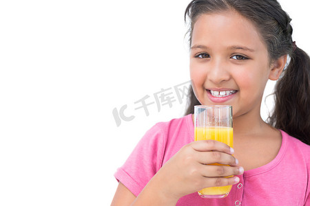 喝橙汁的快乐的小女孩