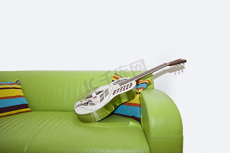 绿色沙发上的谐振器吉他