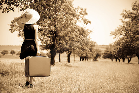 魔女幼熙摄影照片_带着手提箱的孤独的女孩在乡下