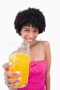 喜庆背景2024摄影照片_一位迷人的少年拿着一杯橙汁