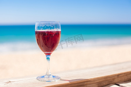 红酒背景摄影照片_杯红酒背景绿松石海