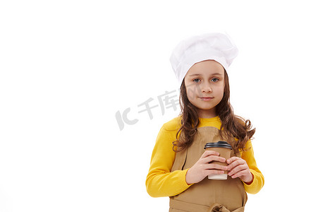 食堂外卖摄影照片_厨师的帽子和围裙的可爱的小女孩。