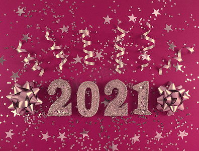 2021 年新年贺卡。粉红色背景上闪闪发光的人物、星星、蝴蝶结和丝带。