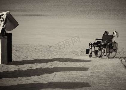 在沙子边缘停放的轮椅