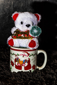 在黑色隔离的圣诞杯中装饰的泰迪熊。