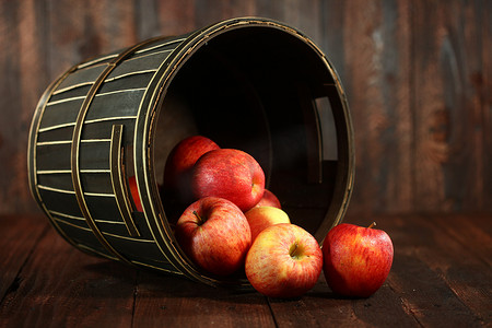 木垃圾背景上装满红苹果的桶