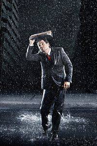 一个年轻商人在雨中奔跑时用活页夹盖住头的全长