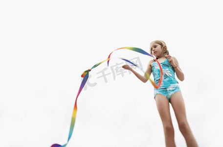 年轻女孩在天空中玩棍子流光的低视角