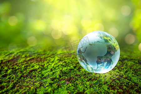 和世界一起说爱你摄影照片_一个拿着玻璃球的男人概念日地球拯救世界拯救环境世界在绿色散景背景的草丛中