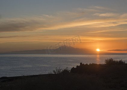 太阳橙色摄影照片_日出前美丽的橙色天空在平静的海洋和从加那利岛拉帕尔马海岸看到的特内里费岛 pico del Teide 山的剪影