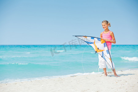 沙滩上玩彩色风筝的可爱女孩