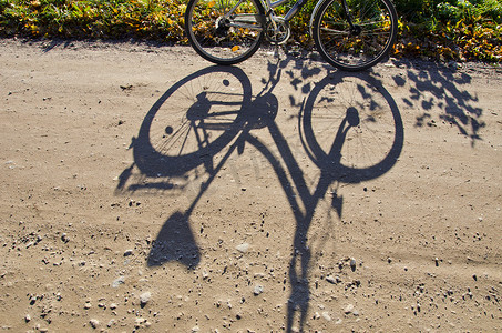 站在砾石路上的自行车影子。