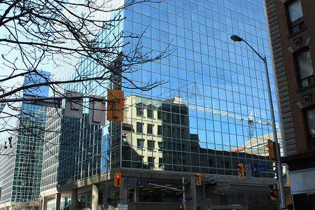 城市浅蓝色摄影照片_塔吊倒映在皇后街的一座建筑上。