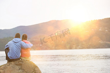 拥抱坐在湖边的夫妇