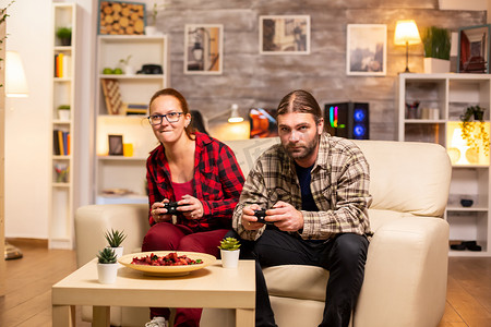 游戏玩家夫妇在电视上玩电子游戏，手里拿着无线控制器