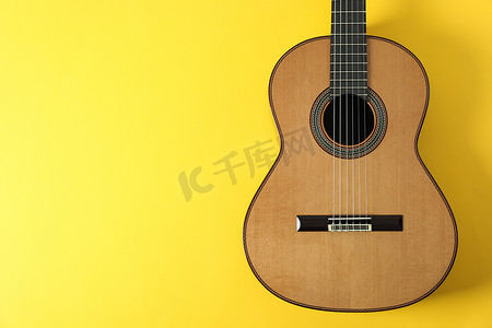 黄色背景中漂亮的古典吉他，文字空间
