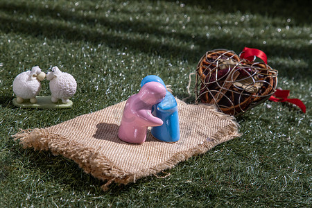 绵羊陶瓷情侣娃娃 在草坪上亲吻和陶瓷情侣娃娃拥抱。