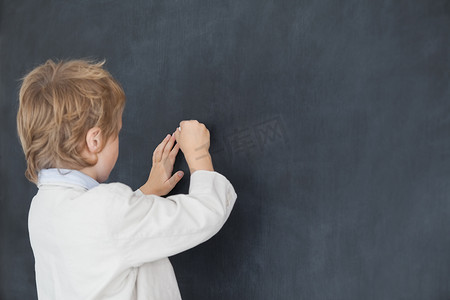 男孩打扮成老师，在黑板上写字