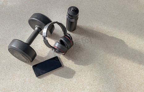 智能手机和耳机、哑铃和水瓶的组成，用于在锻炼时听音乐。