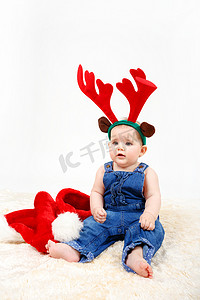 带圣诞老人帽和驯鹿鹿角的小女孩