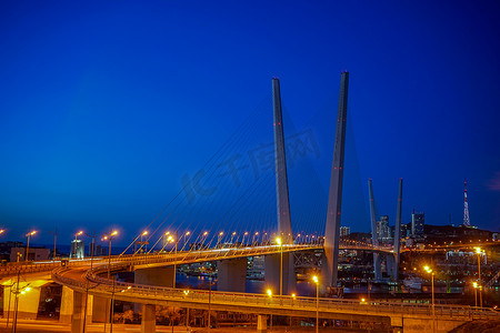傍晚蓝色天空映衬下的金色大桥。