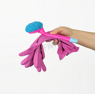 女性手拿着粉红色的清洁手套和白色背景上的刷子