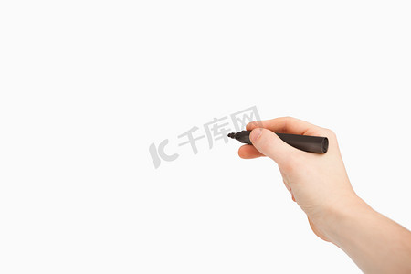 黑色摄影照片_手指拿着黑色毡笔，指着空白