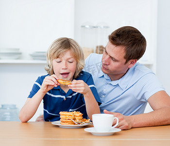 奶可爱摄影照片_吃奶蛋烘饼的迷人的父亲和他的儿子