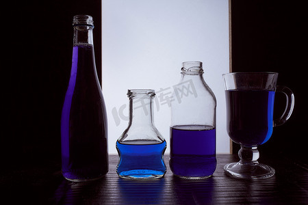 菜单黑金摄影照片_瓶装在浅色背景上，带有蓝色液体