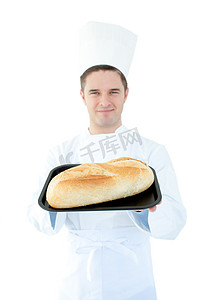 微笑的男厨师拿着面包对着镜头