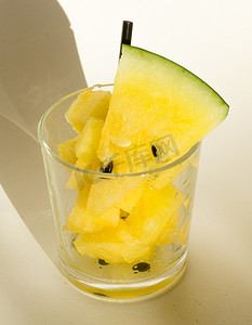 黄西瓜摄影照片_玻璃杯中的黄西瓜，切片用于西瓜饮食