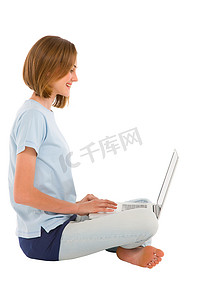 使用膝上型计算机的十几岁的女孩