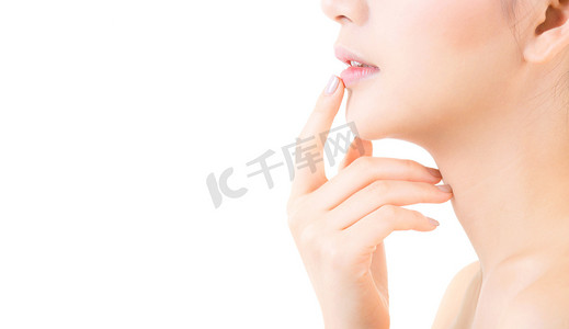 美丽的亚洲年轻女子与干净清新的皮肤接触嘴唇。