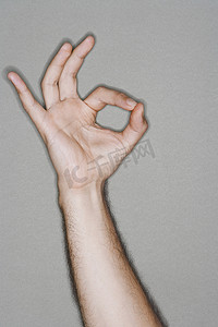 一只手势摄影照片_一只手在灰色背景下做出好的手势的特写