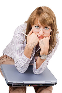 疲惫的年轻女子坐在膝上型电脑旁。