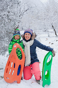 一家人在冬季公园玩雪橇