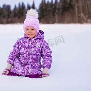 快乐可爱的女孩在冬天阳光明媚的日子里在雪地上玩得开心