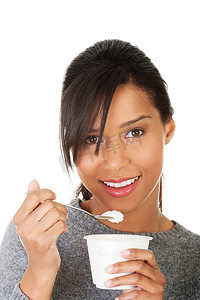 吃酸奶作为健康早餐或点心的年轻女人。