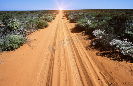 灰尘的旅行摄影照片_在内陆有货车轨道的沙漠公路