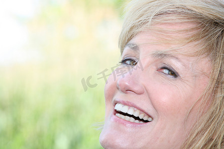 笑容牙齿摄影照片_一个笑容满面的微笑女人的面部特写